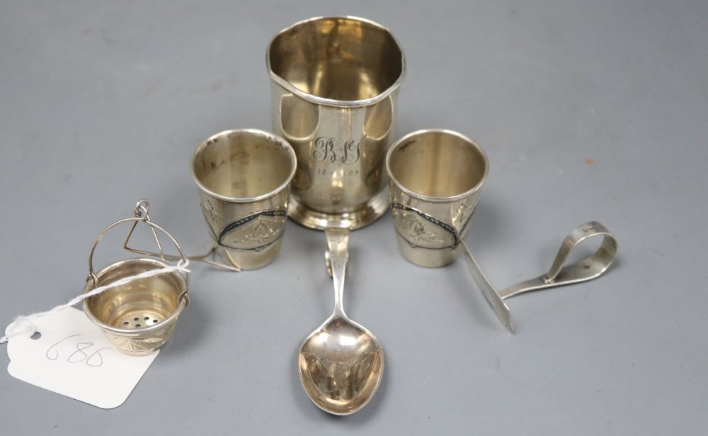 A pair of Russian (1927-1958) white metal and niello tots, a beaker, a strainer? and a spoon and pusher.